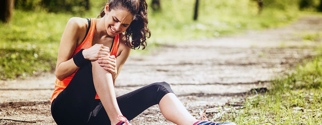 Young woman feeling pain in her knee